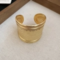 Gros plan sur un bracelet manchette doré avec texture martelée et bordure perlée tressée - Style à Texture Martelée / Or