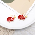 Detail von rot-weißen Emaille-Schafanhängern mit goldenem Metallrand für DIY-Schmuck - Rotes Schaf