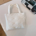 Dettaglio della mini borsa trapuntata bianca con motivo a conchiglia ed etichetta laterale - Stile Trapuntato a Conchiglia