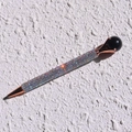 Close-up of sparkling colorful rhinestones on a rose gold metal ballpoint pen - Obsidian