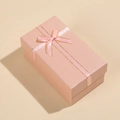 Angled view of a rectangular pink jewelry gift box with a gold-edged ribbon bow - 14x8x6cm / Pink