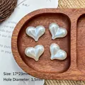 Macro detail of 17x23mm heart-shaped faux pearl beads on a walnut wood tray - White Heart/Peach (17*23mm)