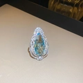 Macro view of pear-cut blue gemstone pendant surrounded by white crystals in silver setting - Style 7 Silver (Blue Teardrop Gemstone)