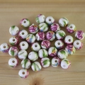 Macro shot of white ceramic beads with pink floral patterns on a light wooden background - No.42-Pink Rose Leaf