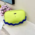 Detail der gelben Crossbody-Tasche aus genarbtem Leder mit blauem Wellen-Schultergurt - Fluoreszierendes Grün