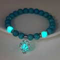 Ciondolo loto luminoso e perle di turchese blu che brillano in un ambiente buio - 8mm Turchese Blu Naturale con Luce Blu-Verde