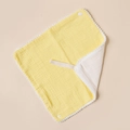 Detail of yellow cotton gauze baby bib with white pom-pom trim and snap fastener - Yellow And White