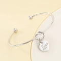 Primer plano detallado de pulsera de acero plateado con colgante de corazón y Love - Color Acero