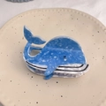 Detail of whale-shaped hair claw clip in blue marbled acetate on a ceramic plate - Blue Round Whale