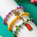 Primer plano de pulseras navideñas de cuentas con copos de nieve, campanas y dijes - Juego de 3 piezas-Púrpura Amarillo Verde Copo de Nieve Bastón de Caramelo Campana