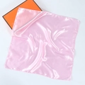 Detailed view of soft pink silk square scarf texture with luxury orange gift packaging - Pink