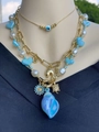 Detailansicht der goldene Mehrlagenkette mit Muschel-Anhängern, Perlen und Teufelsauge - Evil Eye, Delfin-Schnecke und Herzperlen Kombination