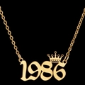 Golden necklace with number 1986 and crown pendant on a minimalist black background - 1986 / Gold