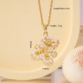 Golden bear necklace with white faux pearl and clear zircon pendant on warm background - Beaded Bear Gold (2795)