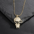 Close-up of a gold-plated boy pendant with sparkling zircons on a dark stone background - Little Boy