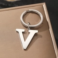 Sleek silver metal letter V keychain displayed on premium brown leather packaging - Letter V