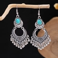 Detailed view of Bohemian turquoise tassel earrings hanging on a rustic wooden branch - E5775-15/Retro Pattern Tassel Turquoise