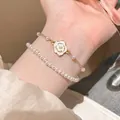 Elegant gold bracelet set featuring white enamel camellia flower and dainty pearls - S542 Gold