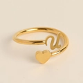 Detail of adjustable gold heart ring with cursive letter u on a neutral background - Letter U