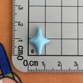 Gros plan d'un accessoire en résine d'étoile bleu clair de 1,5 cm sur une règle - Bleu