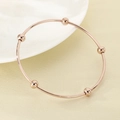 Dettaglio del bracciale in acciaio inossidabile oro rosa con cinque perline lucide - Diametro interno 60mm / Anello singolo / Oro rosa