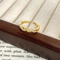 Detail of twisted gold ring with pavé cubic zirconia on a vintage jewelry box edge - Adjustable Open / Gold