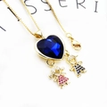 Macro shot of gold necklace featuring large heart blue crystal and paved boy girl charms - Boy Girl Heart / Pendant And Necklace