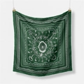 Macro detail of silk scarf with paisley patterns, tassels and keys on dark green fabric - Green
