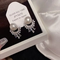 Dettaglio di orecchini in argento con foglie di zirconi scintillanti su velluto nero - Argento (Perla Bianca)