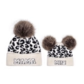 Detail of leopard print knitted hats featuring MAMA and MINI embroidery with pom-poms - Leopard-MAMA + MINI