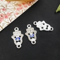 Detailed macro view of silver Hamsa hand charms with blue eyes and sparkling rhinestones - Bright Silver - Hamsa Hand Connector - 12x21mm