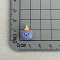 Close-up of small blue resin bear with yellow hat on measuring mat, 2cm size detail - Blue Bear with Yellow Hat