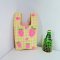 Macro detail of yellow knitted strawberry pattern tote bag with white checkered texture - Yellow Strawberry