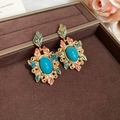 Détail macro de boucles d'oreilles vintage dorées avec turquoise et décor en émail - Clous d'oreilles turquoise avec motif émaillé et tige en argent