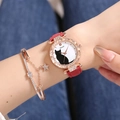 Detail of a rose gold cat motif watch and star bracelet on a woman wrist - Red + Bracelet