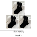 Three-pair pack of black mid-calf socks with ruffle trim and vertical ribbed knit pattern - Black