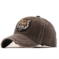 Dettaglio del cappello in cotone invecchiato con ricamo testa di tigre e cuciture a contrasto - caffè