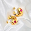 Dettaglio orecchini a C dorati con zirconi rosa e viola su seta bianca lussuosa - Oro