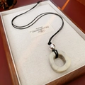 Détail d'un pendentif géométrique en marbre blanc sur un collier cordon noir en bois - Rond Irrégulier (Blanc-Gris) / Blanc Grisâtre