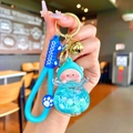 Détail d'un porte-clés cochon mignon avec bouteille à paillettes bleues et clochette - Cochon Pêche Flocon de Neige Lumineux Bleu Clair