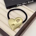 Golden brushed metal heart hair tie with dual cutout design on a black elastic band - Double Hollow Heart / Gold