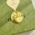 Detailed view of green paisley embossed gift box with Feliz Navidad gold label decoration - Spanish Merry Christmas Style 1