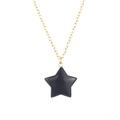 Detail of a polished black agate star pendant on a fine golden necklace chain - Gold Chain + Obsidian
