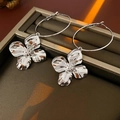 Macro-opname van zilveren metalen bloemoorbellen in een luxe donkerbruine sieradendoos - Bloemen creolen / Zilver