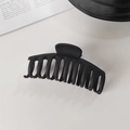 Vue détaillée d'une grande pince à cheveux noire mate pour queue de cheval sur fond blanc - Pince à Cheveux Forme de Quille Noire