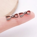 Gunmetal jewelry pendant bail connector for DIY necklaces shown on a fingertip - Gun Black