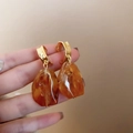 Detail shot of irregular amber resin earrings with gold metal hoops on hand - 19# Silver Pin Brown Irregular Square