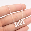 Detailed close-up of 1991 year number pendant in Gothic font on a steel cable chain - 1991 / Steel