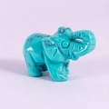 Blue-green turquoise style elephant figurine with black texture on purple fabric - Turquoise Howlite