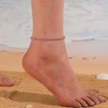 Detail of beaded turquoise crystal anklet worn on ankle at a sandy beach during vacation - 3.5mm / Amethyst Purple